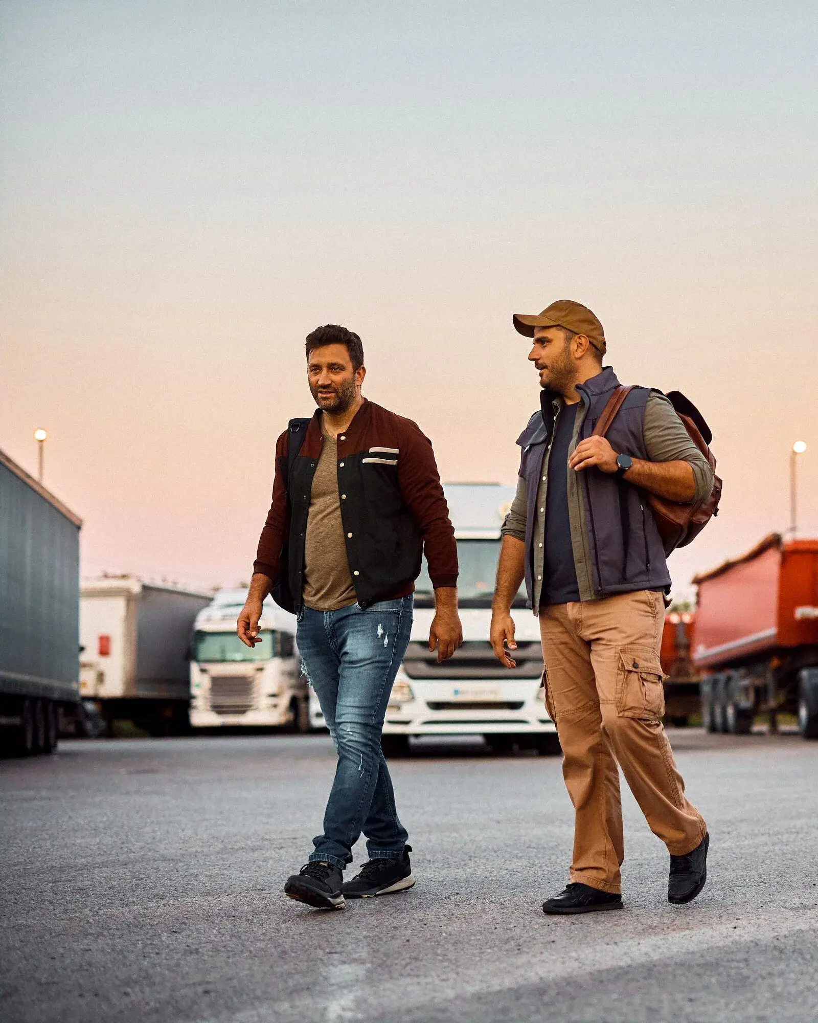 Professional truck drivers talking while walking on parking lot. Copy space. mvp